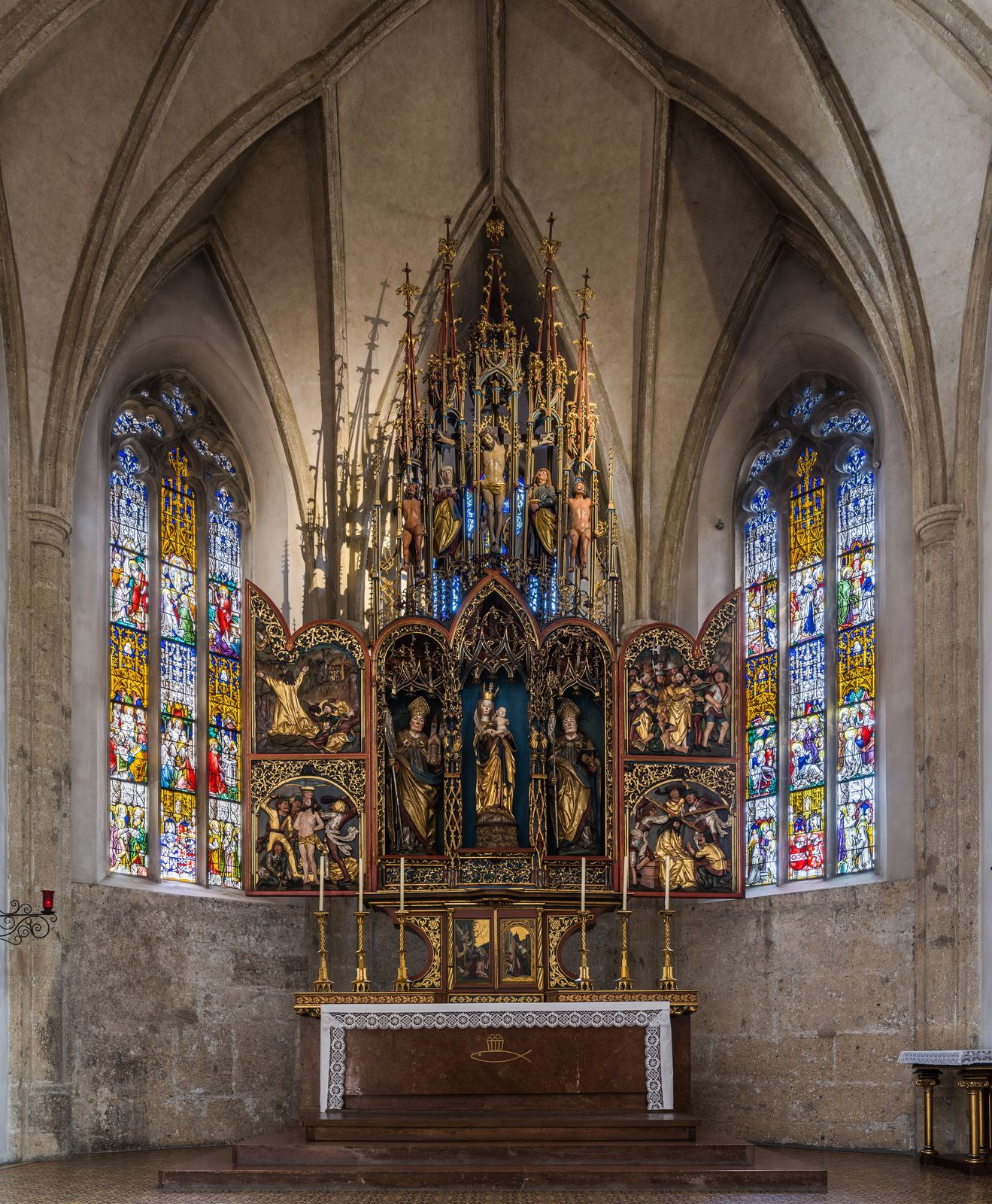 The Gothic high altar of Nonnberg Abbey in Salzburg, between two stained-glass windows